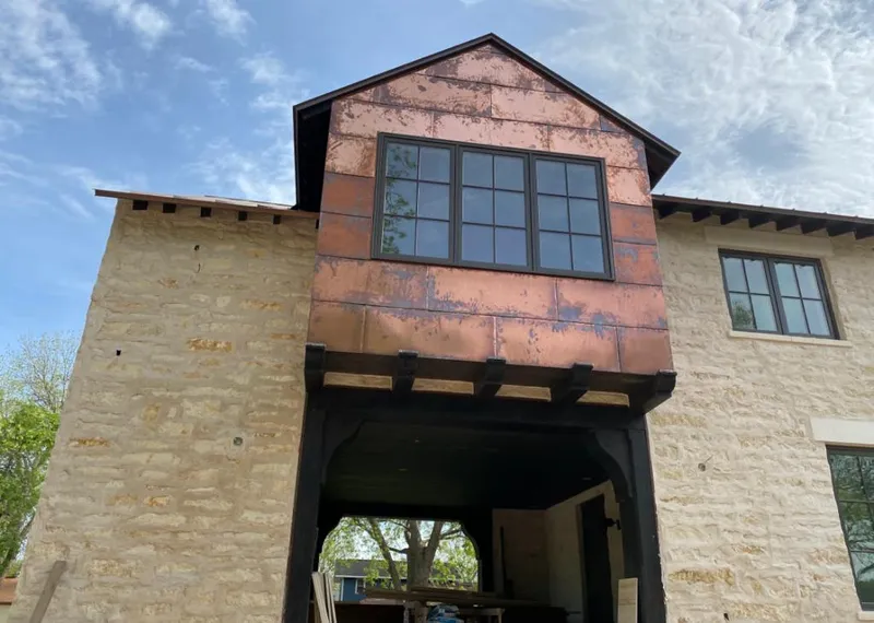 Copper metal panel facade on a stone building for Skylight Installation in Martha Lake